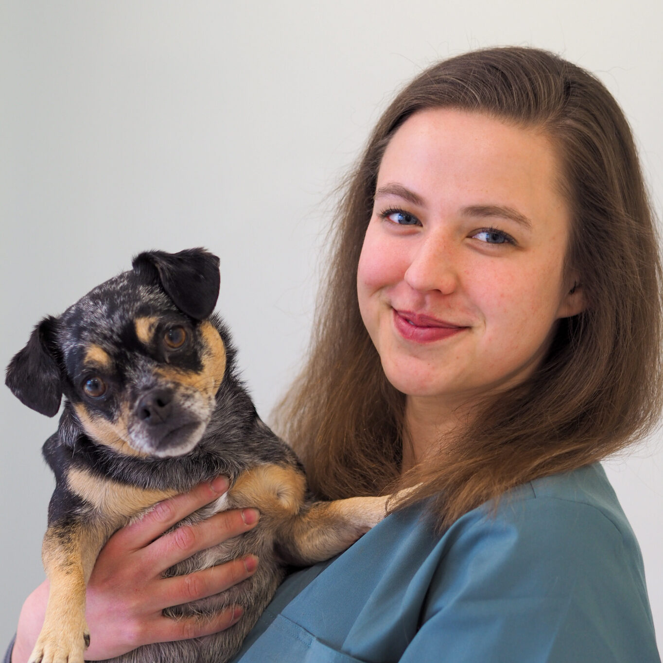 Portraitbild der TFA Marie Weizenmann, die lächelnd einen kleinen Hund auf dem Arm hält