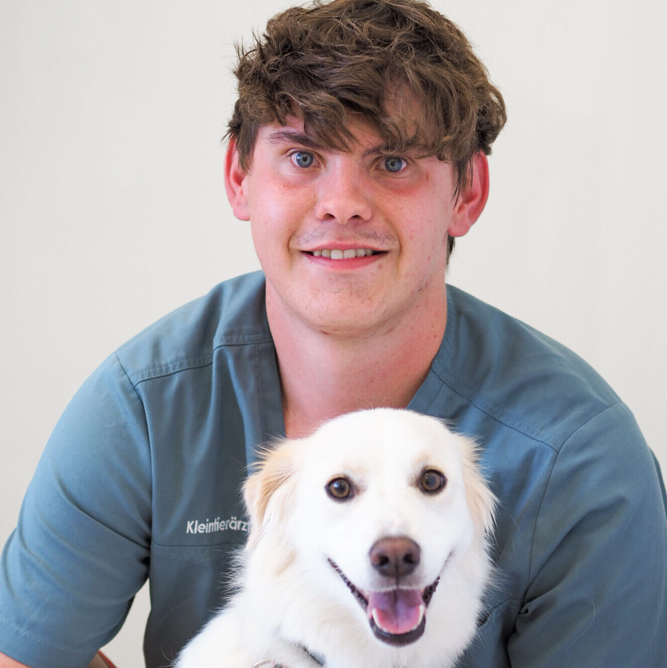 Portraitbild TFA Nic Dilger mit weißem Hund